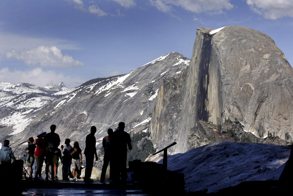 FILE - In this 2005 file photo, visitors view Half Dome from Glacier Point at Yosemite National Park, Calif. A massive sheet of rock has fallen from the vertical face of Half Dome in Yosemite National Park, making one of the most popular routes attempted by climbers in North America even more challenging, park officials said Tuesday, July 7, 2015. (AP Photo/Dino Vournas, File)
